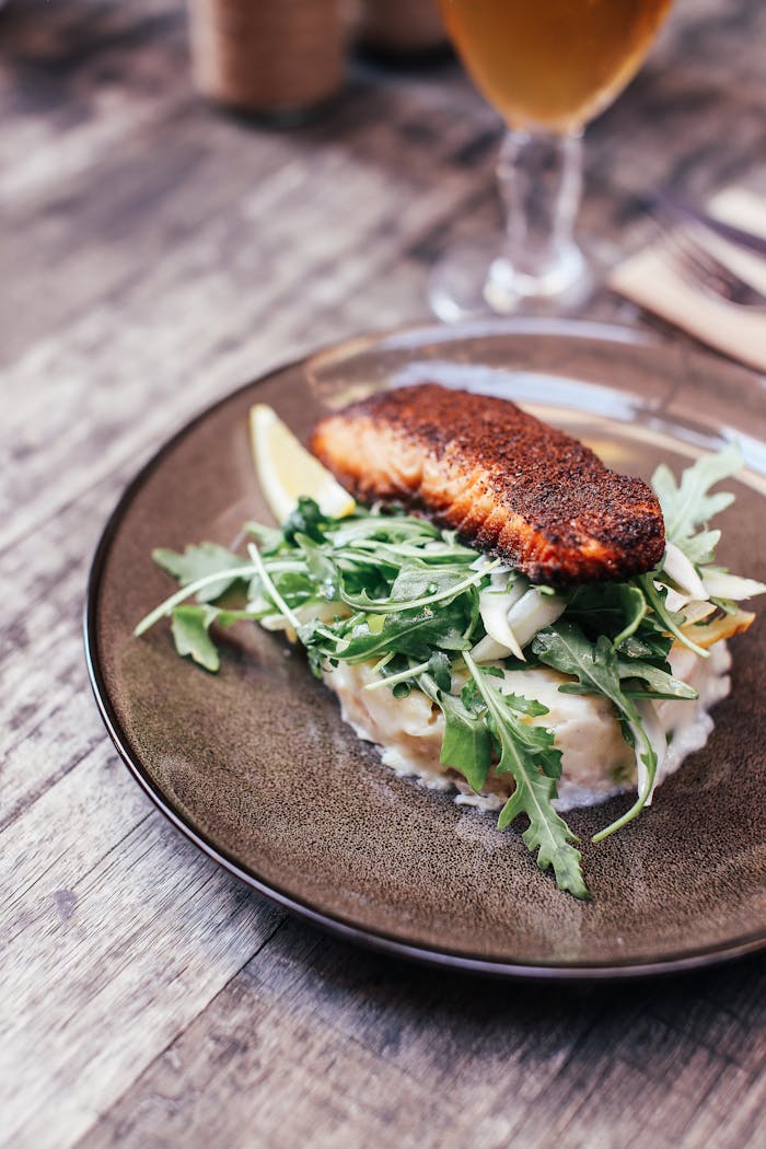 Delicious grilled salmon served on creamy mashed potatoes with fresh arugula salad.